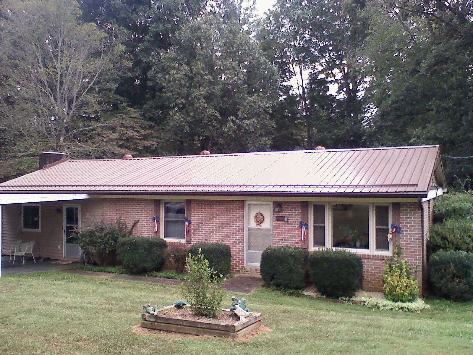 Bronze metal roof on a brick ranch home with a carport in Auburn
